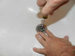 Откручивание металлической бляшки слива ваны
